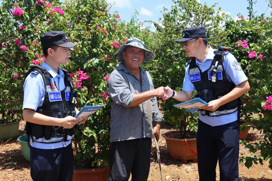 “鲜花警务室”的民警上门对花农进行反诈宣传，之前得到过民警帮助的“熟面孔”老万感激地握住民警的手。记者连蒙 摄.jpg