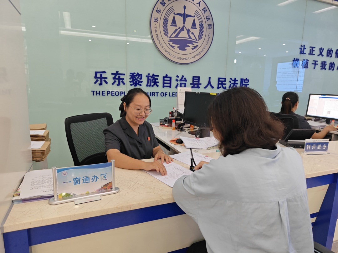 在乐东法院诉讼服务中心，唐莹莹为群众提供服务。记者覃创源 摄.jpg